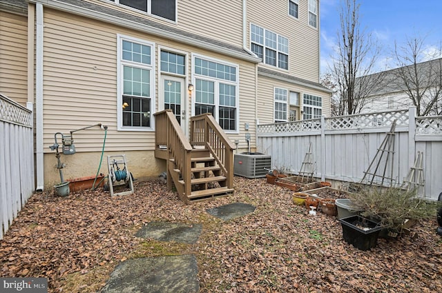 doorway to property with cooling unit and fence