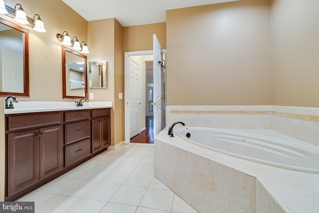 bathroom with tile patterned flooring, a garden tub, a sink, and double vanity