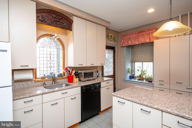 kitchen with black dishwasher, hanging light fixtures, freestanding refrigerator, white cabinetry, and a sink