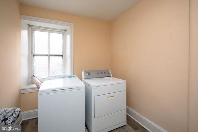 washroom featuring laundry area, washer and clothes dryer, baseboards, and wood finished floors