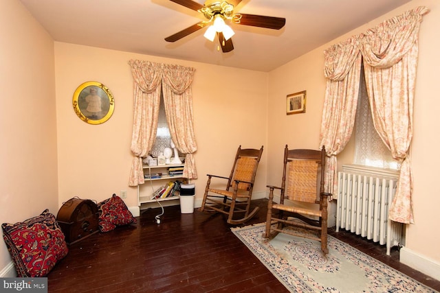 sitting room with ceiling fan, radiator heating unit, hardwood / wood-style flooring, and baseboards