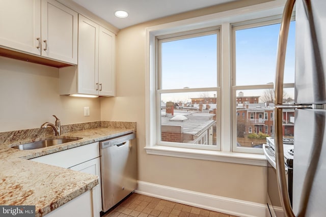 kitchen featuring a wealth of natural light, baseboards, dishwasher, and a sink