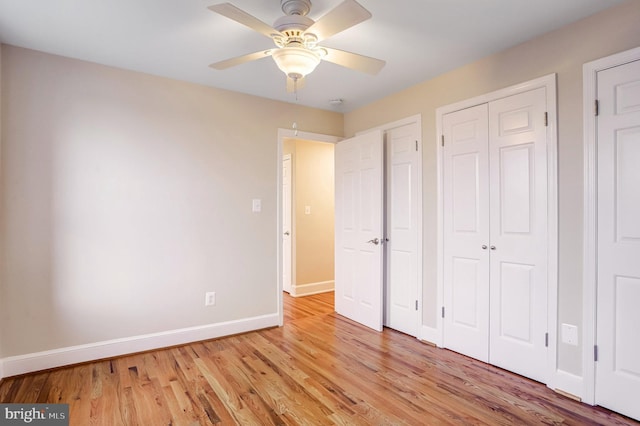 unfurnished bedroom with light wood-style floors, baseboards, and a ceiling fan