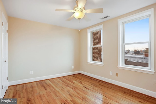 unfurnished room featuring baseboards, visible vents, plenty of natural light, and light wood finished floors