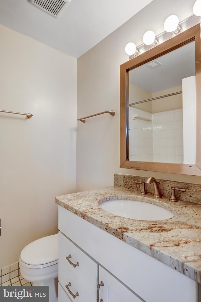 bathroom with toilet, vanity, visible vents, tile patterned floors, and walk in shower