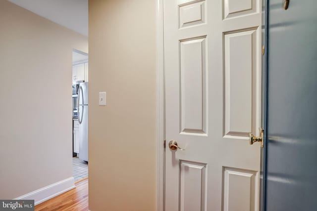 hallway featuring light wood-type flooring and baseboards