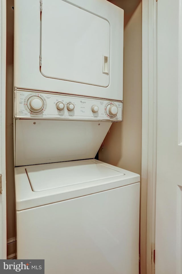 washroom featuring stacked washer / drying machine