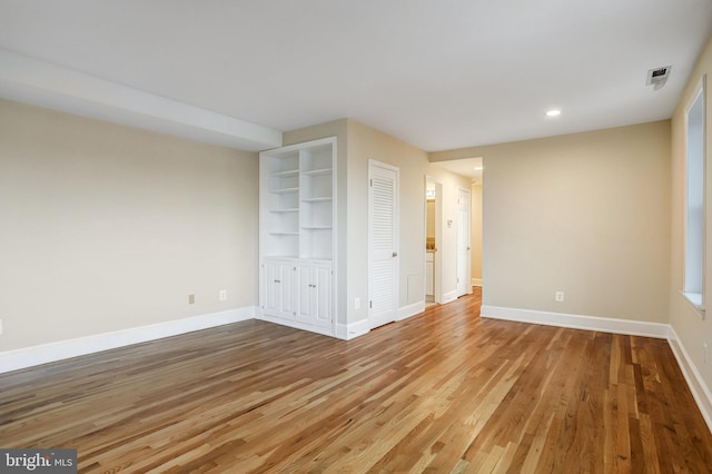 unfurnished bedroom featuring recessed lighting, a closet, visible vents, wood finished floors, and baseboards