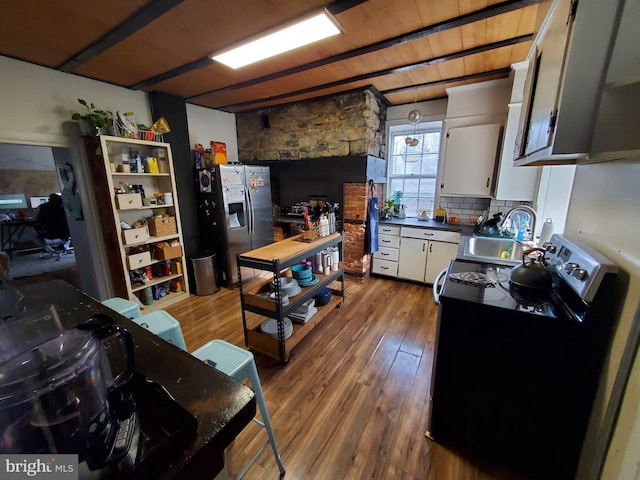 kitchen featuring electric range, stainless steel fridge with ice dispenser, wood finished floors, white cabinetry, and a sink