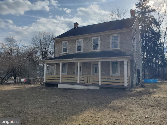 view of front of property with covered porch and a chimney