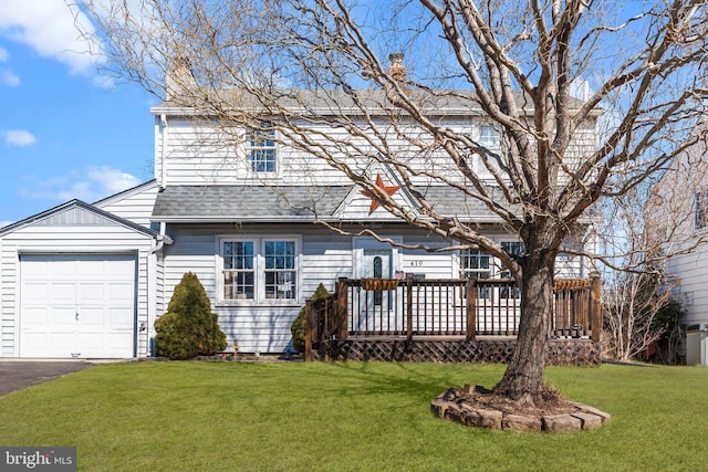 rear view of house with a garage, a yard, roof with shingles, a wooden deck, and a chimney