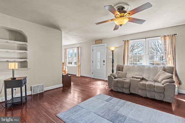 living area with built in features, baseboards, visible vents, and hardwood / wood-style floors