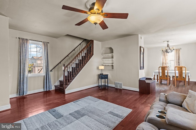 living area featuring plenty of natural light, stairway, wood-type flooring, and baseboards