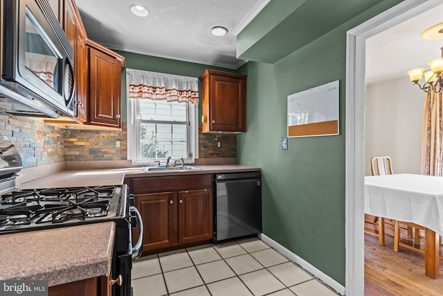 kitchen with tasteful backsplash, an inviting chandelier, a sink, black appliances, and baseboards