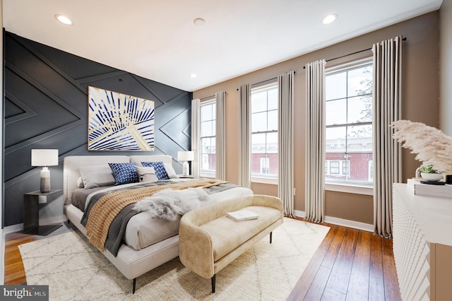 bedroom featuring recessed lighting, multiple windows, baseboards, and wood finished floors