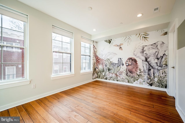 empty room featuring hardwood / wood-style floors, recessed lighting, and baseboards