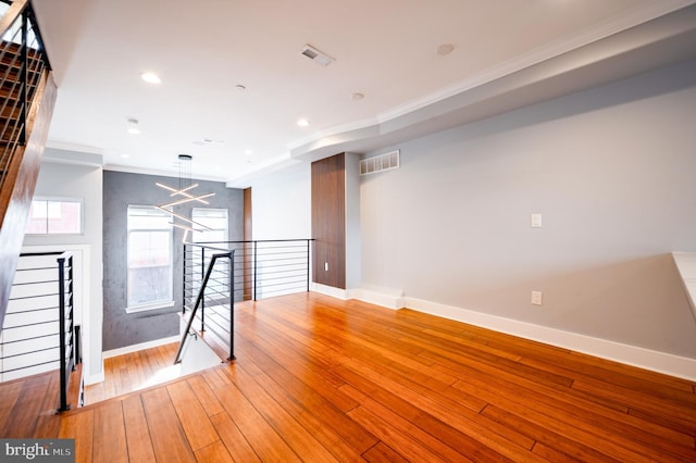 unfurnished room featuring hardwood / wood-style floors, recessed lighting, visible vents, and crown molding