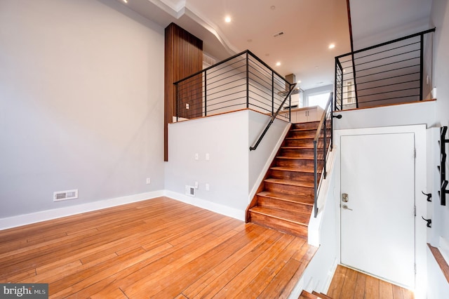 stairs featuring hardwood / wood-style flooring, baseboards, visible vents, and recessed lighting