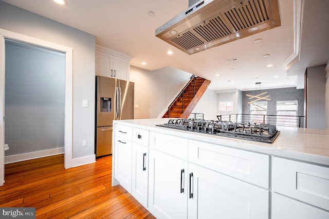 kitchen with recessed lighting, light wood-style floors, white cabinets, appliances with stainless steel finishes, and range hood