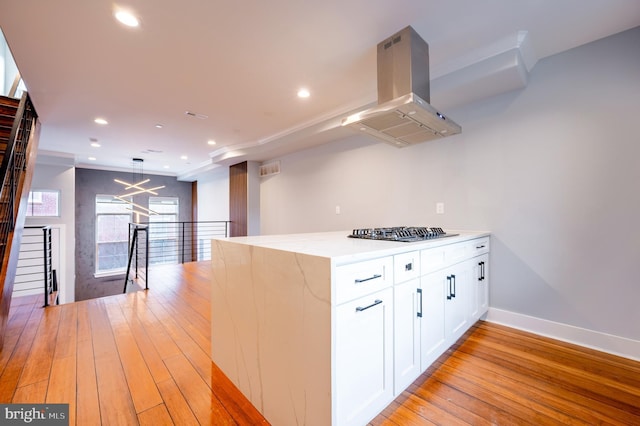 kitchen featuring stainless steel gas cooktop, light wood finished floors, recessed lighting, white cabinets, and island range hood