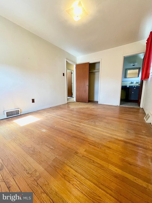 unfurnished bedroom with a closet, visible vents, and light wood finished floors