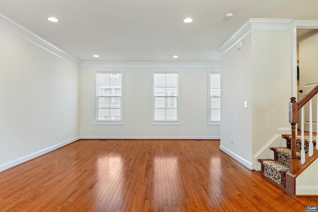 spare room with recessed lighting, baseboards, stairs, ornamental molding, and light wood finished floors