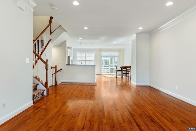 spare room featuring ornamental molding, recessed lighting, baseboards, and wood finished floors