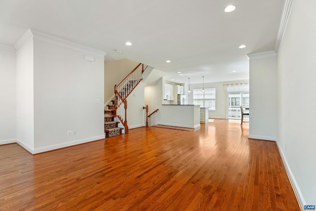 unfurnished living room with baseboards, ornamental molding, wood finished floors, and recessed lighting