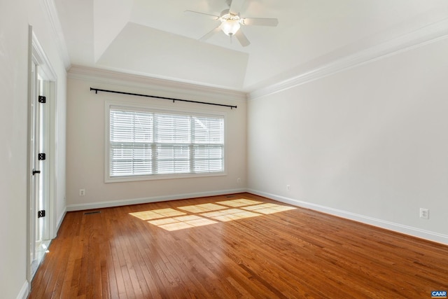 spare room featuring ceiling fan, baseboards, ornamental molding, a tray ceiling, and hardwood / wood-style floors