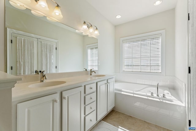 full bath featuring double vanity, a sink, a bath, and tile patterned floors