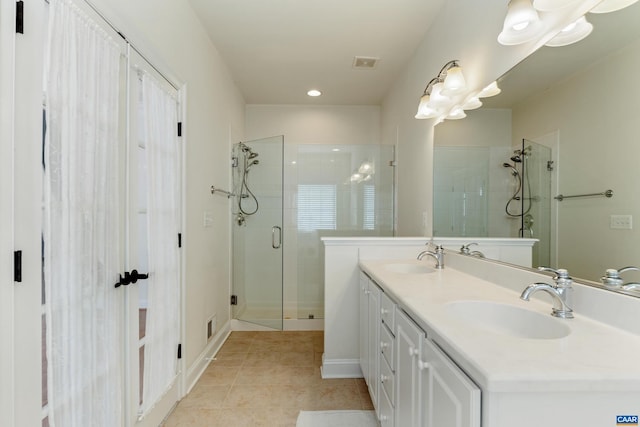 full bath with tile patterned flooring, a shower stall, visible vents, and a sink