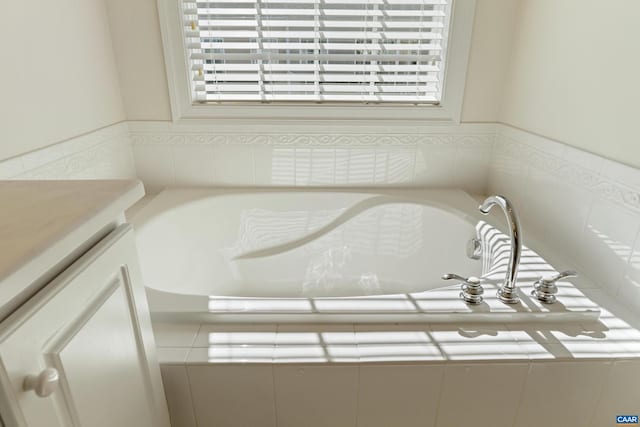 full bathroom with vanity and a bath