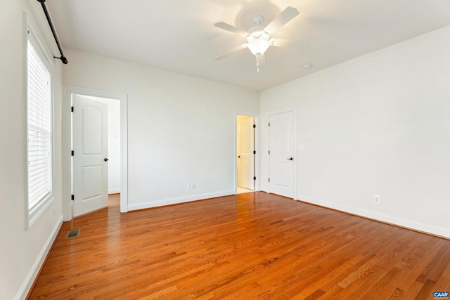 interior space with light wood finished floors, baseboards, visible vents, and ceiling fan