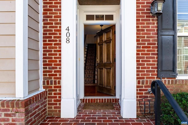 view of exterior entry featuring brick siding