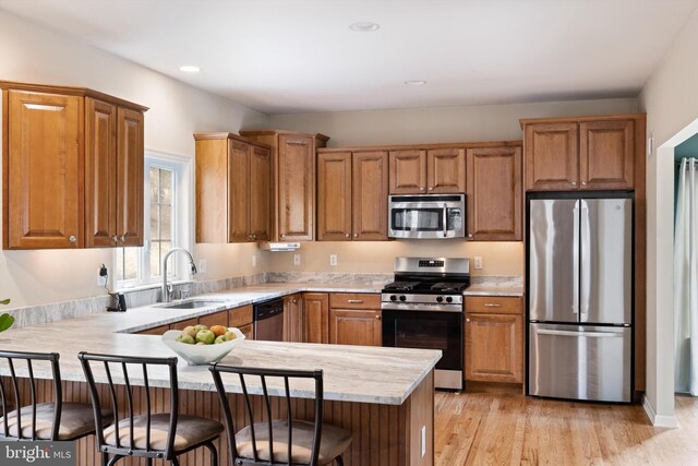 53 S Main St, Stockton, NJ 08559 - kitchen featuring light countertops, a peninsula, stainless steel appliances, a sink, and brown cabinetry