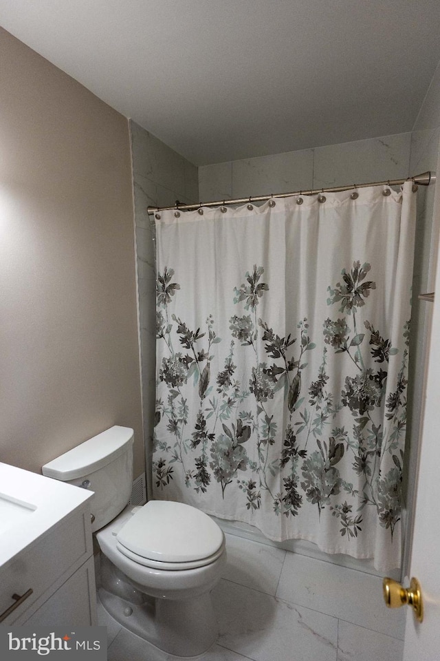 bathroom featuring curtained shower, vanity, and toilet