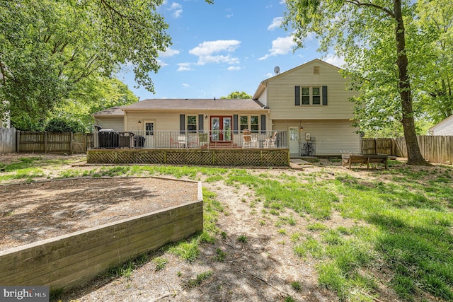 rear view of house with a deck, french doors, and a fenced backyard