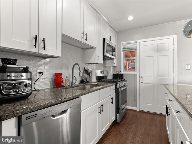 kitchen featuring dark wood-style floors, appliances with stainless steel finishes, white cabinets, and a sink