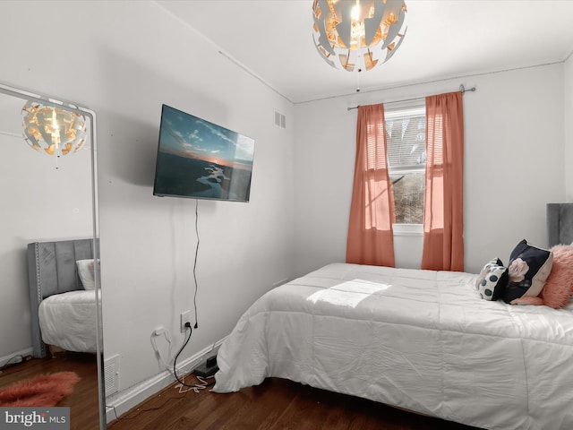 bedroom with visible vents and wood finished floors