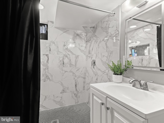 full bathroom featuring a marble finish shower and vanity