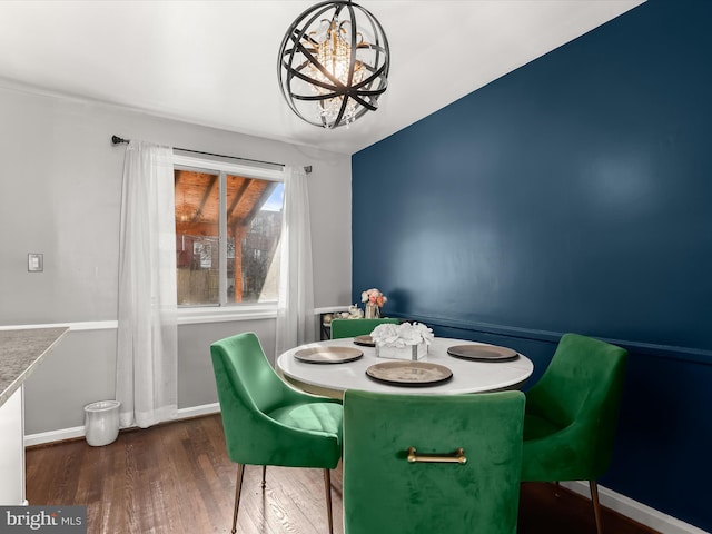 dining area featuring an inviting chandelier, baseboards, and wood finished floors