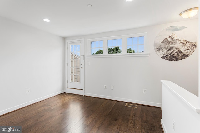 spare room featuring recessed lighting, baseboards, and wood finished floors