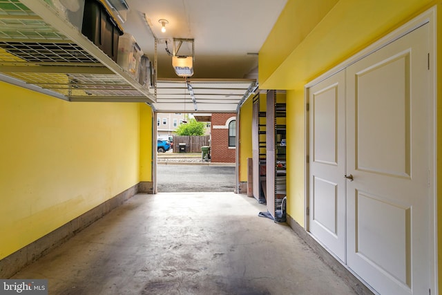 garage featuring a garage door opener and baseboards