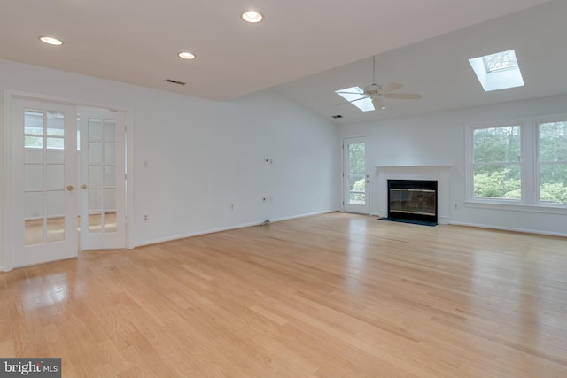 unfurnished living room with recessed lighting, visible vents, a fireplace with flush hearth, light wood-type flooring, and baseboards