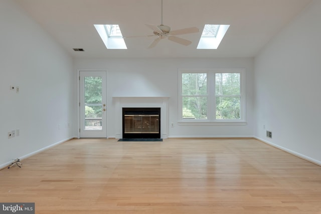 unfurnished living room featuring lofted ceiling, plenty of natural light, visible vents, and light wood-style flooring