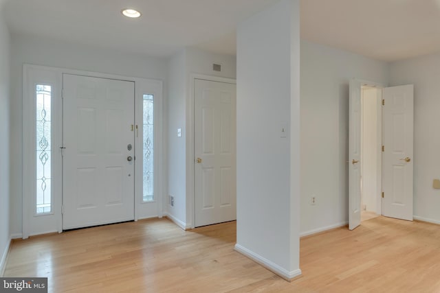 foyer with plenty of natural light, light wood-style flooring, and baseboards