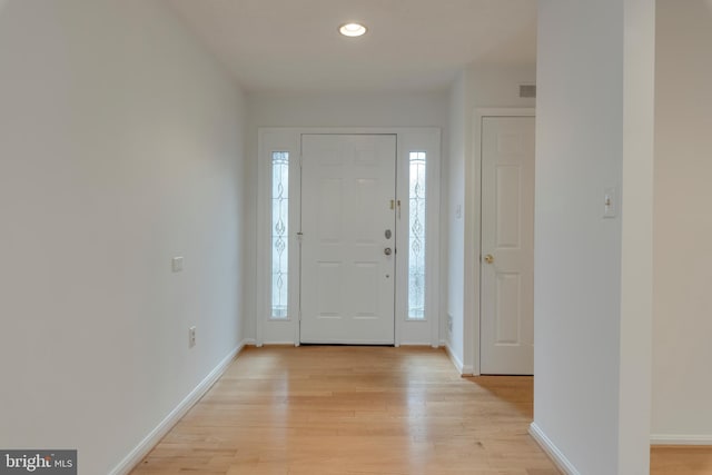 foyer featuring light wood finished floors, baseboards, and recessed lighting