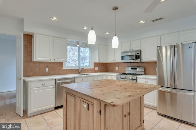 kitchen featuring light tile patterned floors, tasteful backsplash, visible vents, appliances with stainless steel finishes, and wood counters