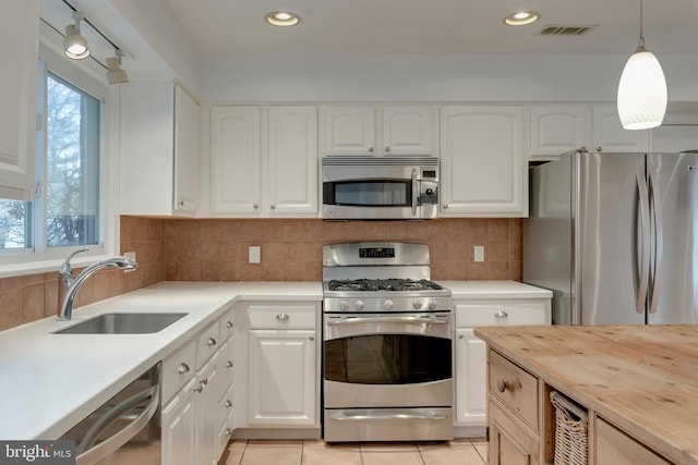 kitchen with tasteful backsplash, visible vents, butcher block counters, appliances with stainless steel finishes, and a sink