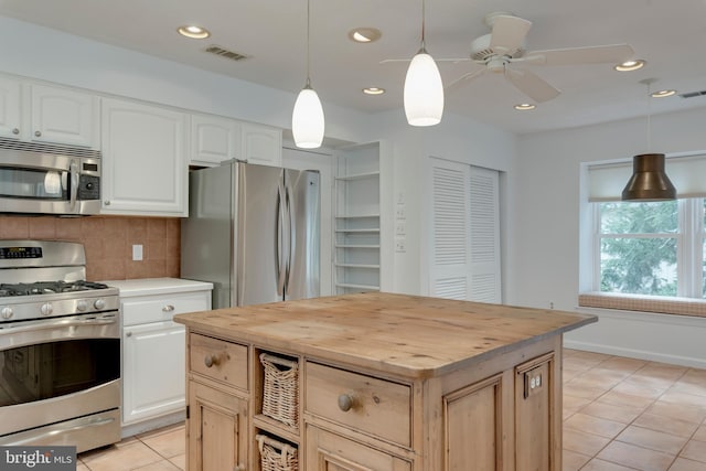 kitchen with light tile patterned floors, butcher block countertops, visible vents, appliances with stainless steel finishes, and decorative backsplash